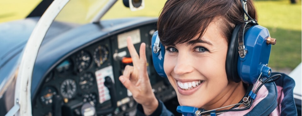 Flugschülering lächelt im Cockpit nach ihrer Flugstunde